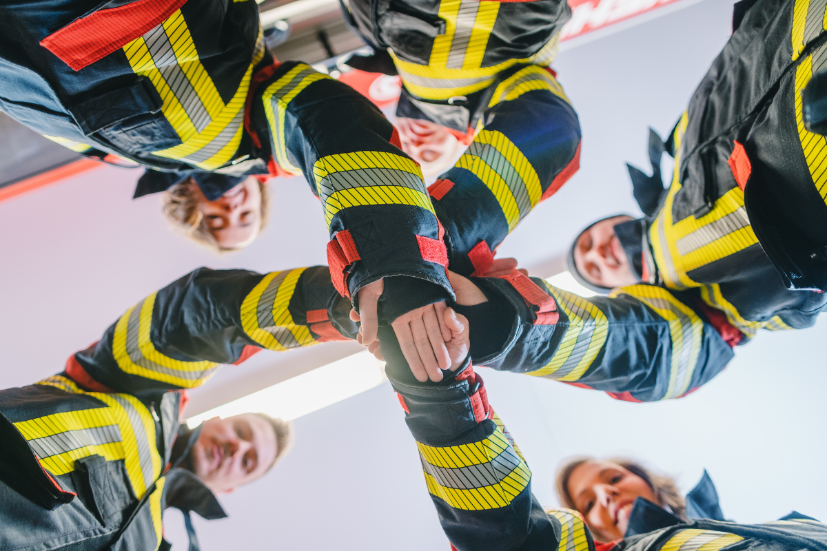 Firefighting group joining hands in the middle