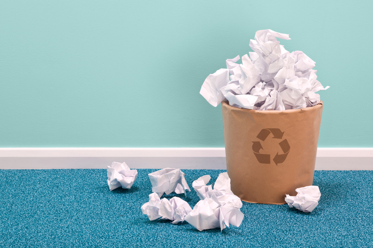 Recycling bin with surrounding paper