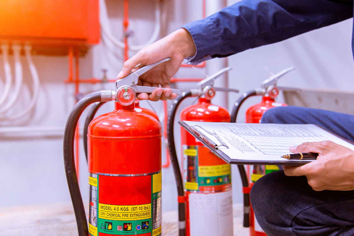 Fire extinguisher getting checked with man with clipboard