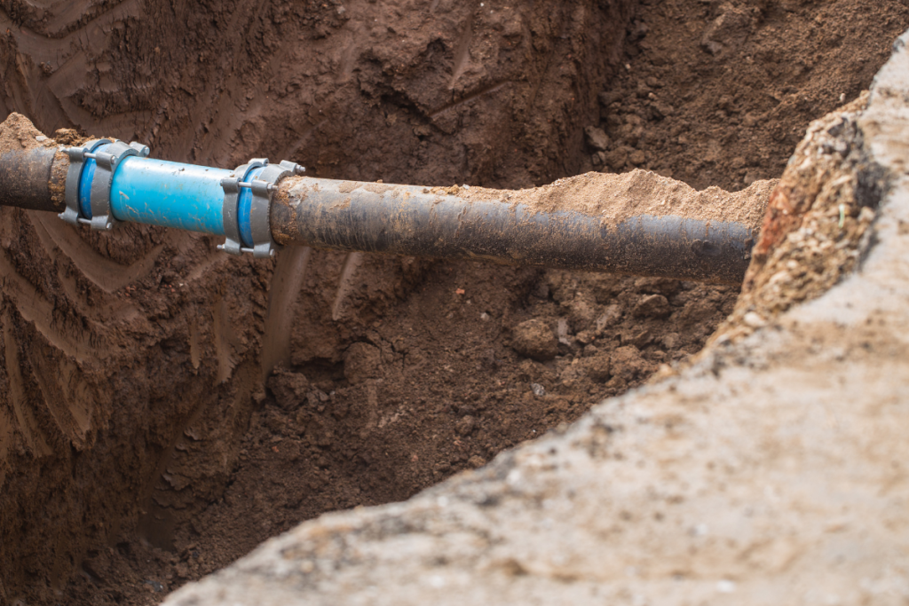 A gas pipe that has been dug out and uncovered from the ground with a repair having been made to it