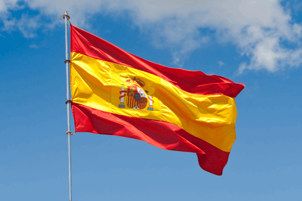 Spanish flag with blue sky and clouds