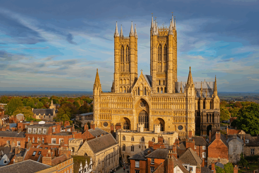 Lincolnshire Cathedral with dark skies and other smaller buildings surrounding the cathedral