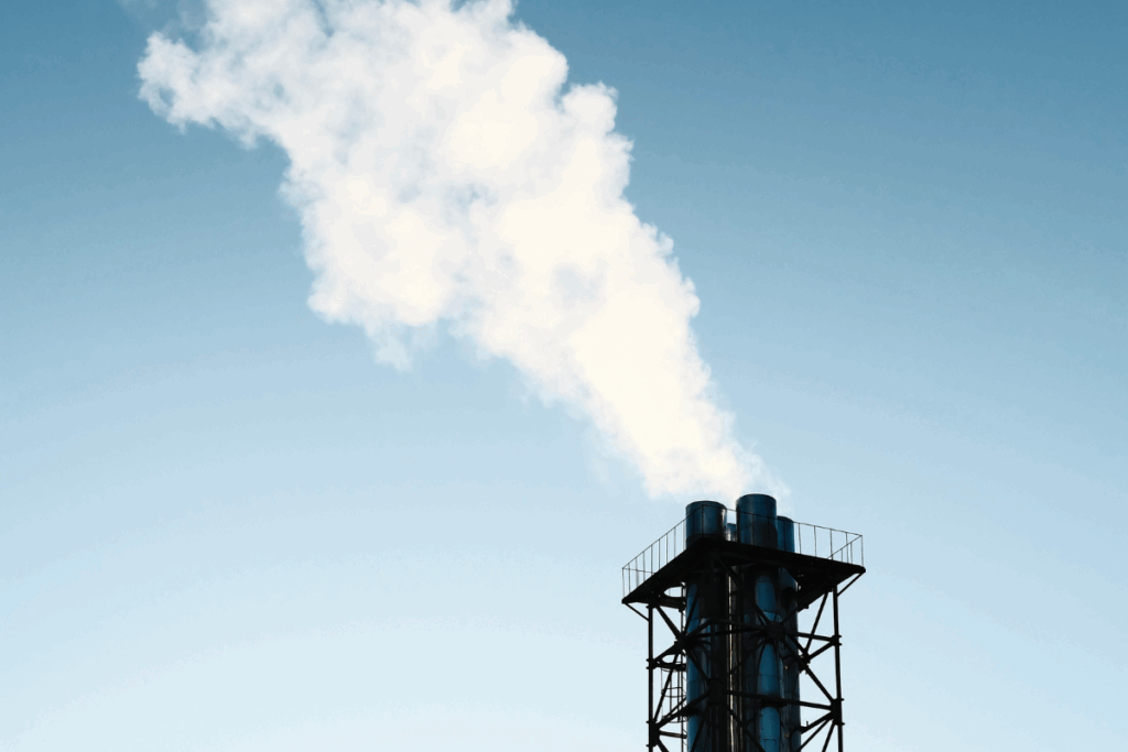 Close-up of particulate matter emissions going into the air, with a grey and blue sky