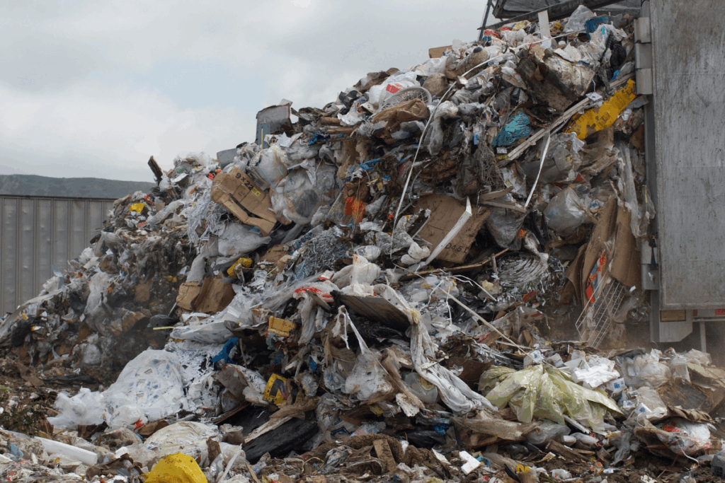 A large pile of waste that has been dumped with a grey sky behind it