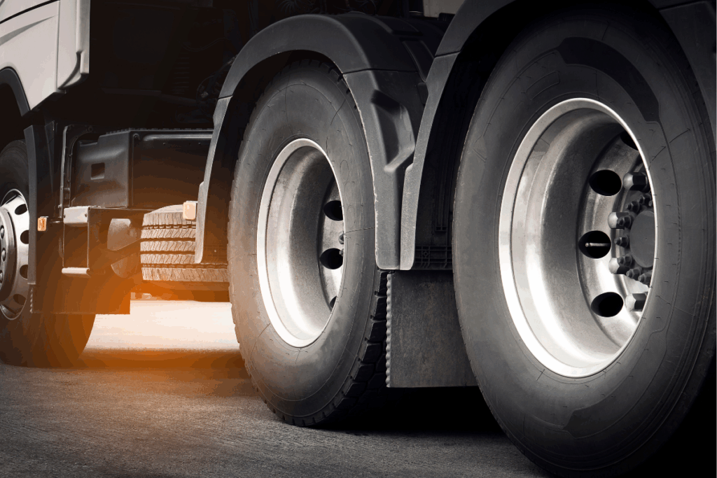 Close up of a HGV truck's wheels with sun shining through the gaps of the rubber wheels