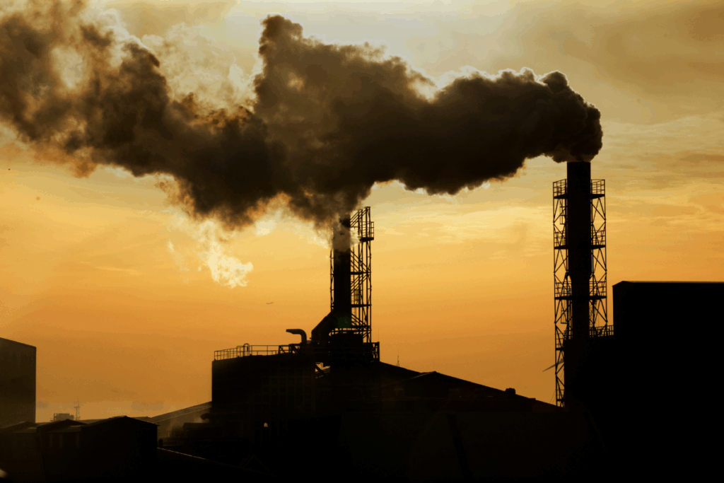 Yellow and orange skyline with clouds and air-polluting smoke released into the air