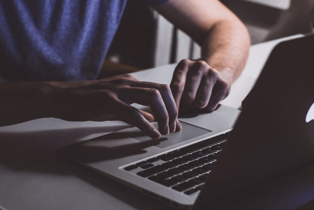 A man working on a laptop with dark lighting