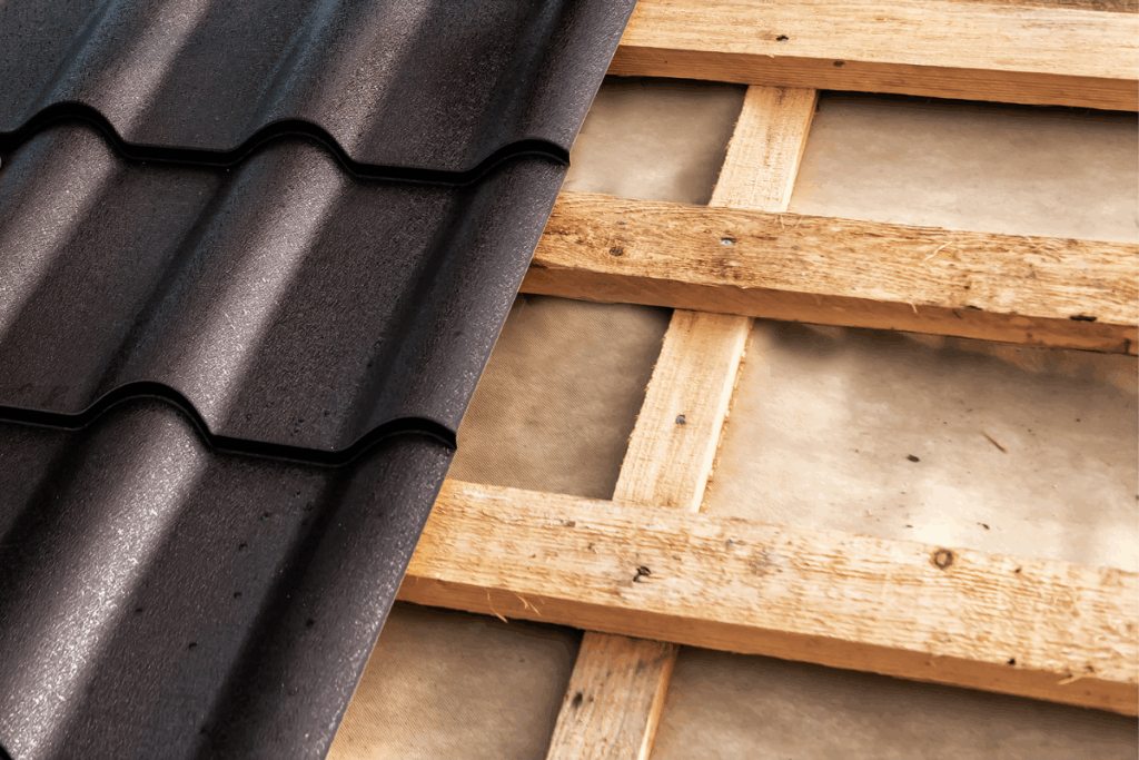 Partially constructed barn roof. Half wood, half roofing tiles.