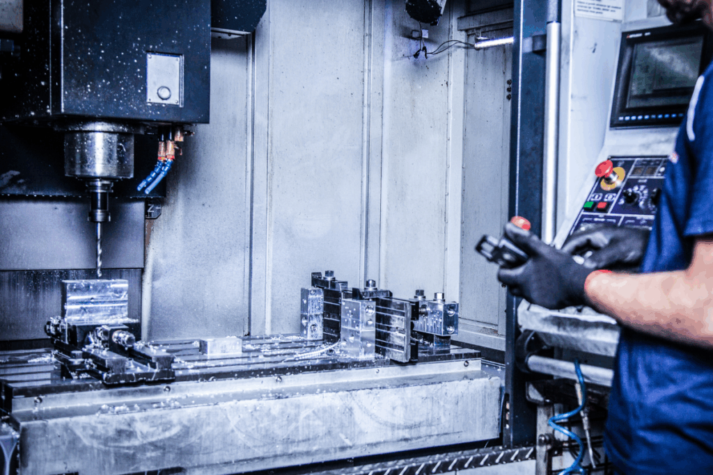 A radial-arm drill in use with an operator stood nearby