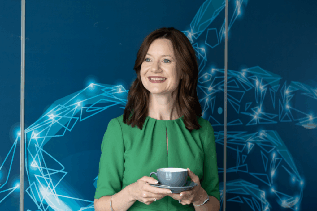 Elizabeth Hyde the speaker of the webinar holding a cup of tea smiling