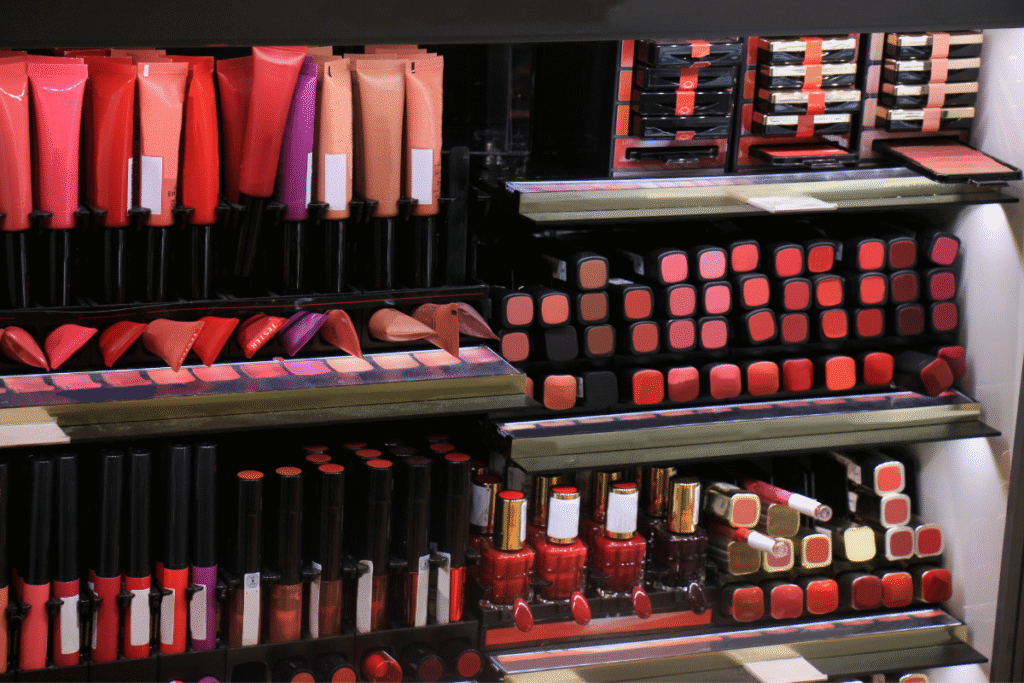 Cosmetics display holder with a variety of different makeup products and colours.