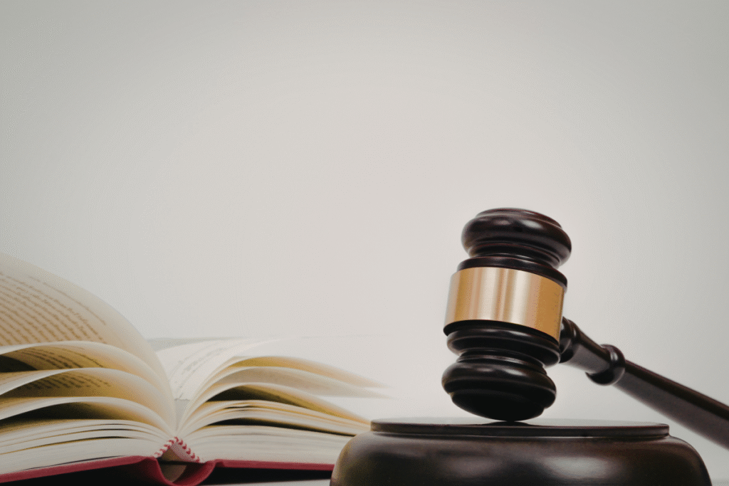 A judge's gavel and an open book with a white background