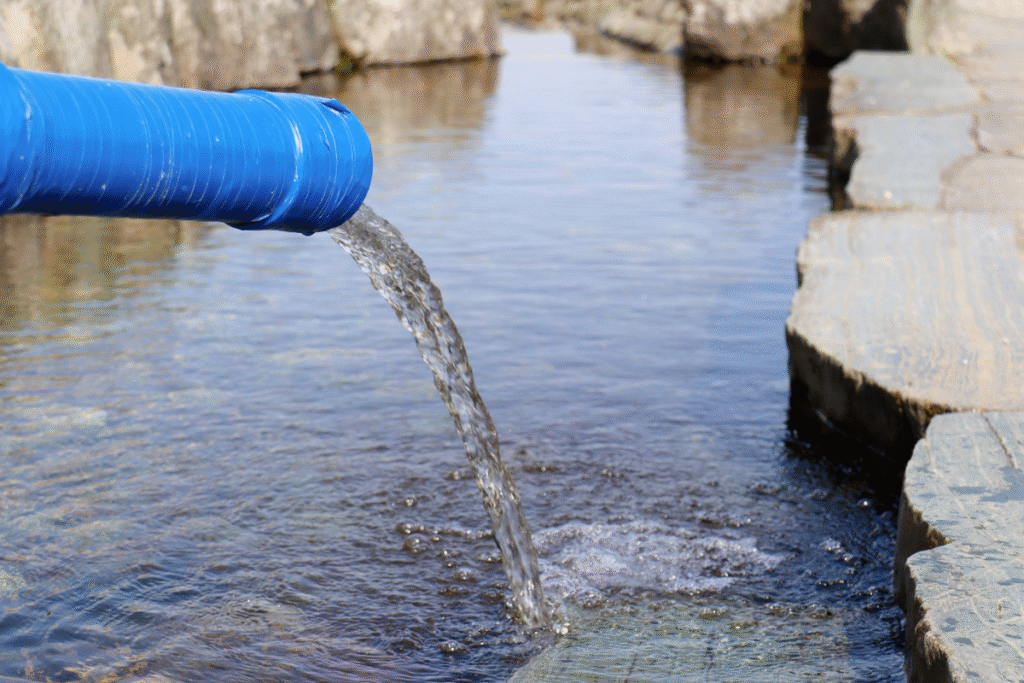 Water pollution treatment with blue pipe and water flowing from it