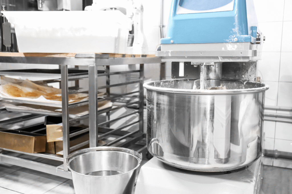 an industrial dough mixing machine with a large chrome mixing bowl