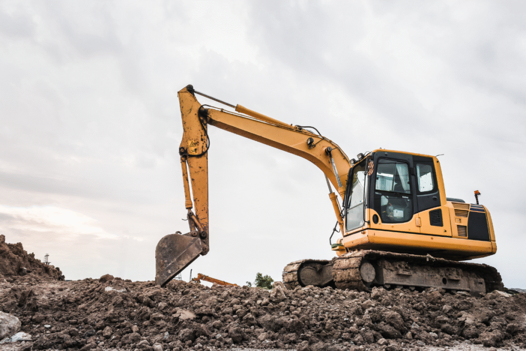 yellow loading shovel on site with grey sky behind it and aggregated beneath