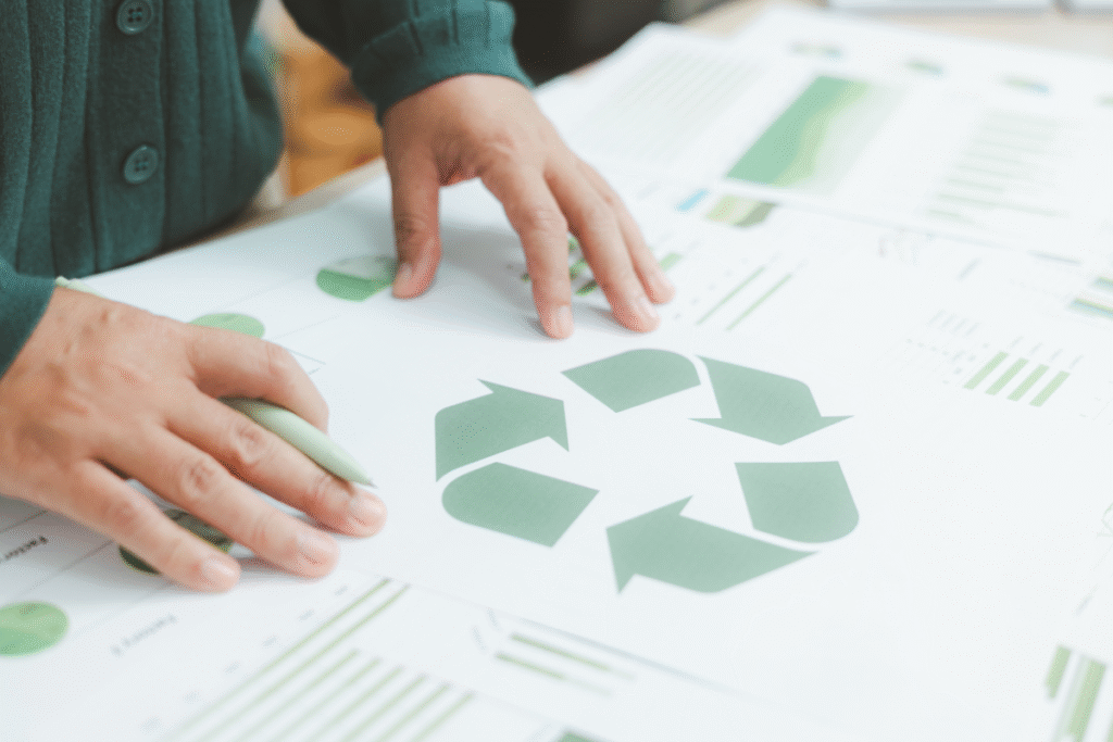 A person with their hands placed on paperwork with the recycling icon on