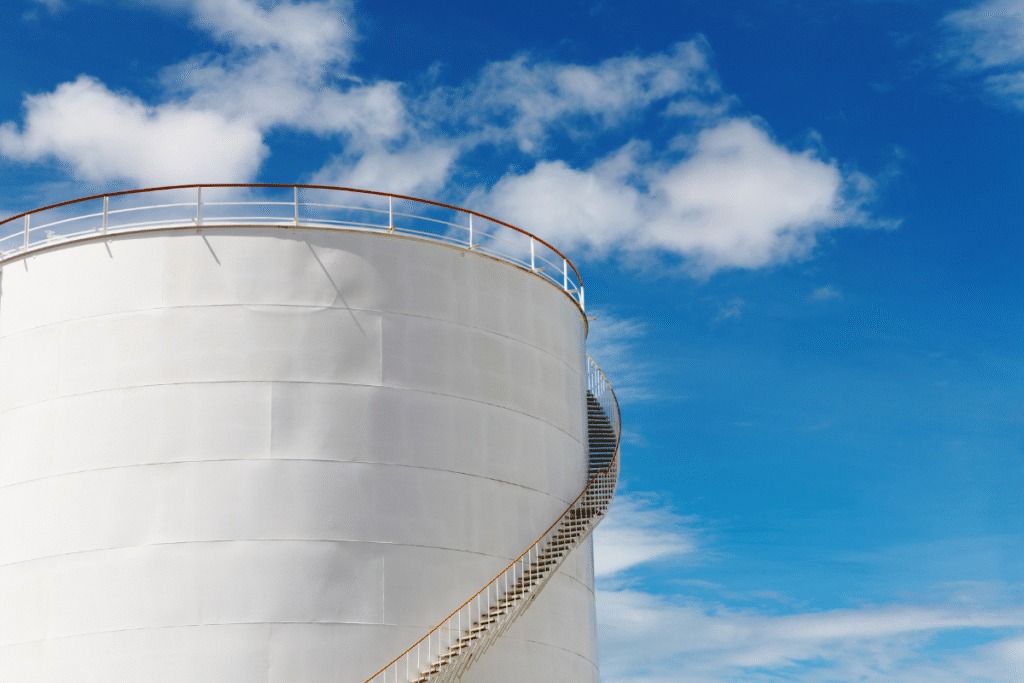 White static industrial Fuel Plant with blue sky and clouds behind it