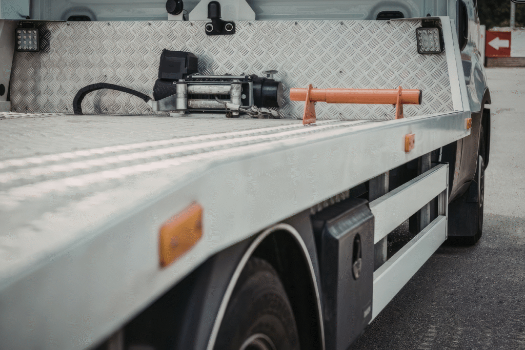 a silver flatbed truck vehicle with tyres showing