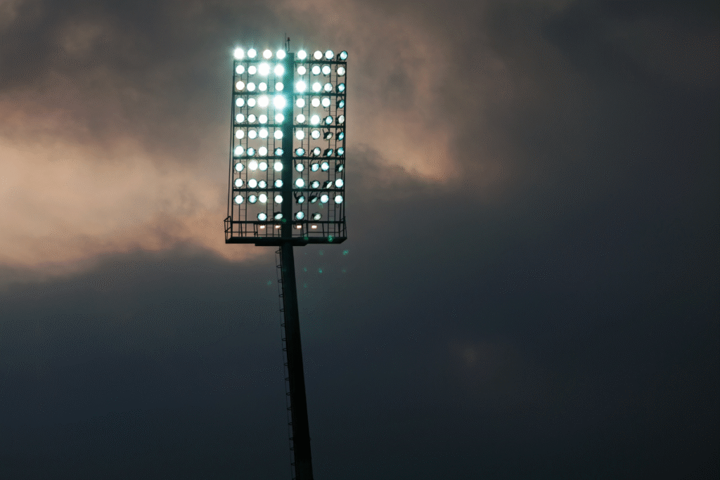 Floodlight on a sports pitch in the dark and grey sky and clouds behind it
