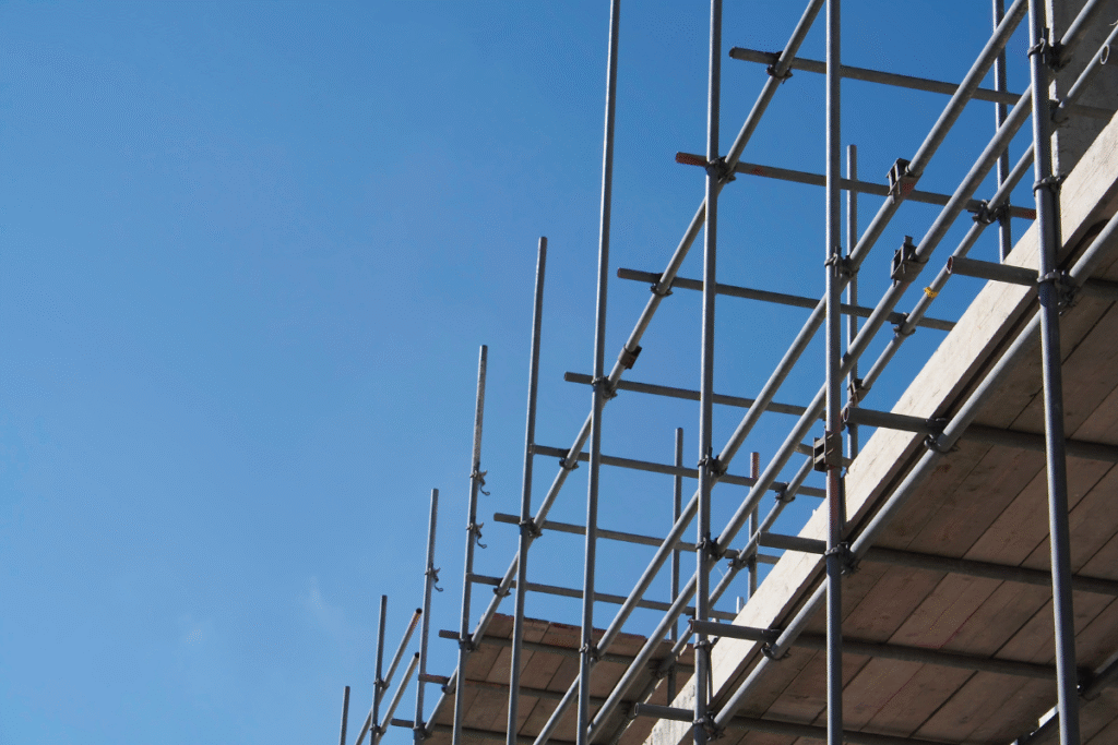 Scaffolding on a building with wallboards and blue sky