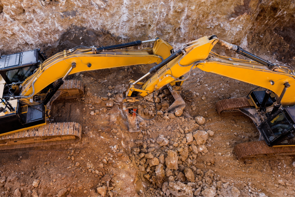 Two excavation vehicles in an excavation hole