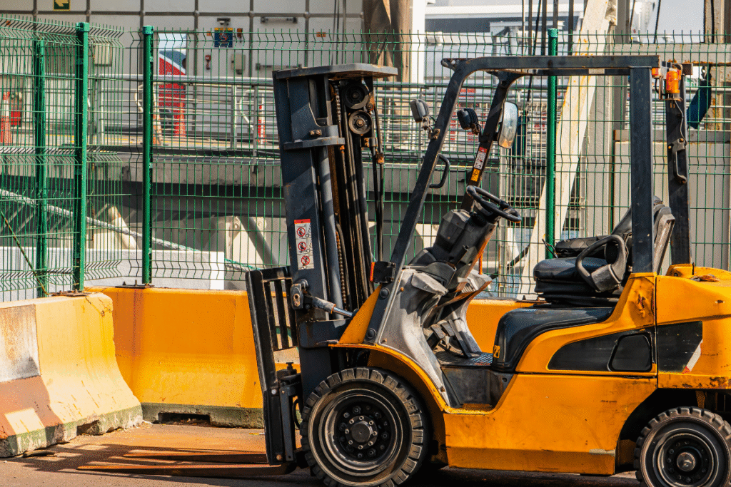 An orange and black forklift truck parked on site